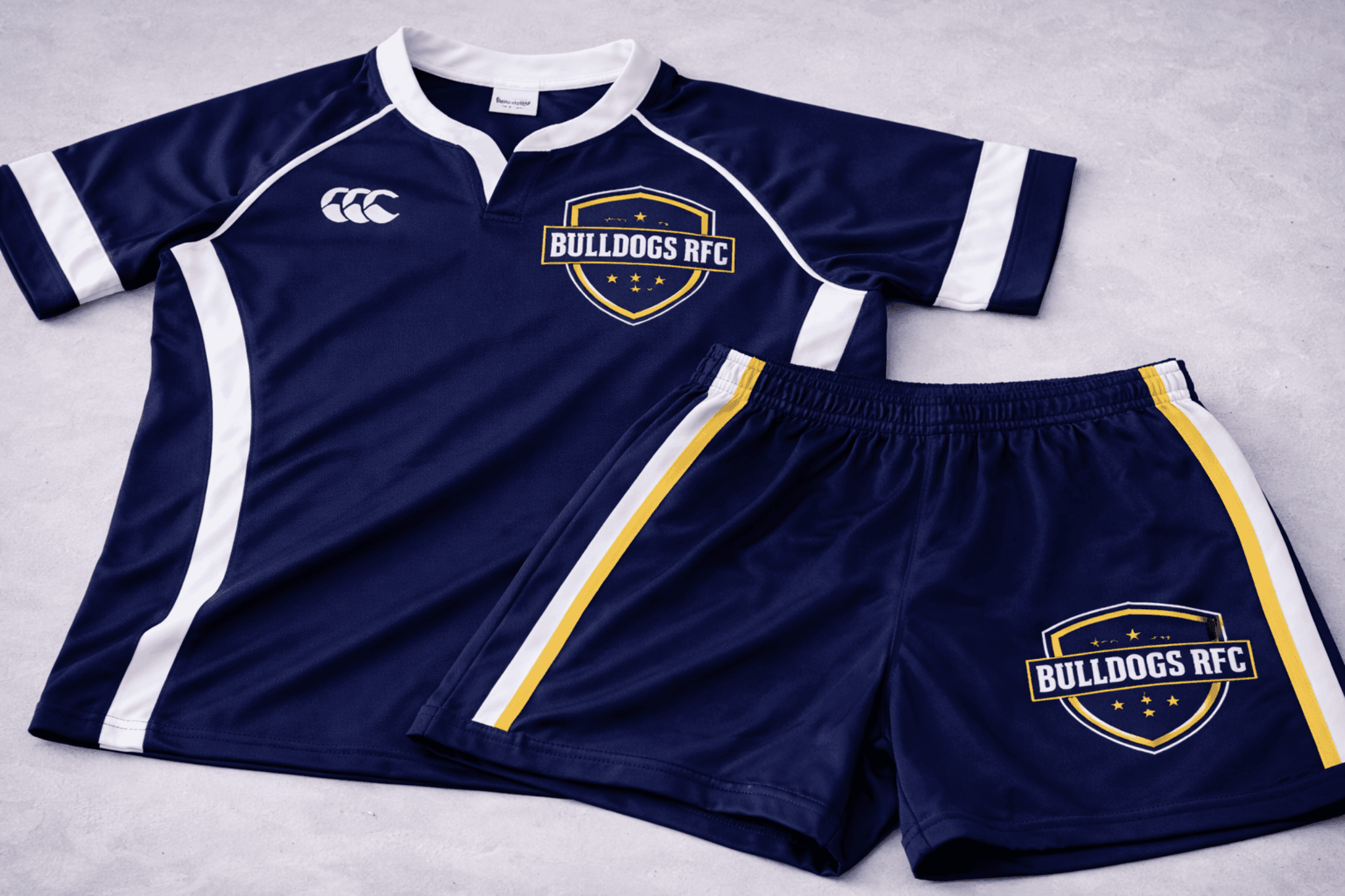 Navy blue Bulldogs RFC rugby jersey and shorts with white trim and yellow crests.